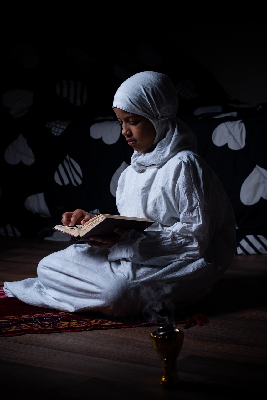 Young girl in hijab reading the Quran after school